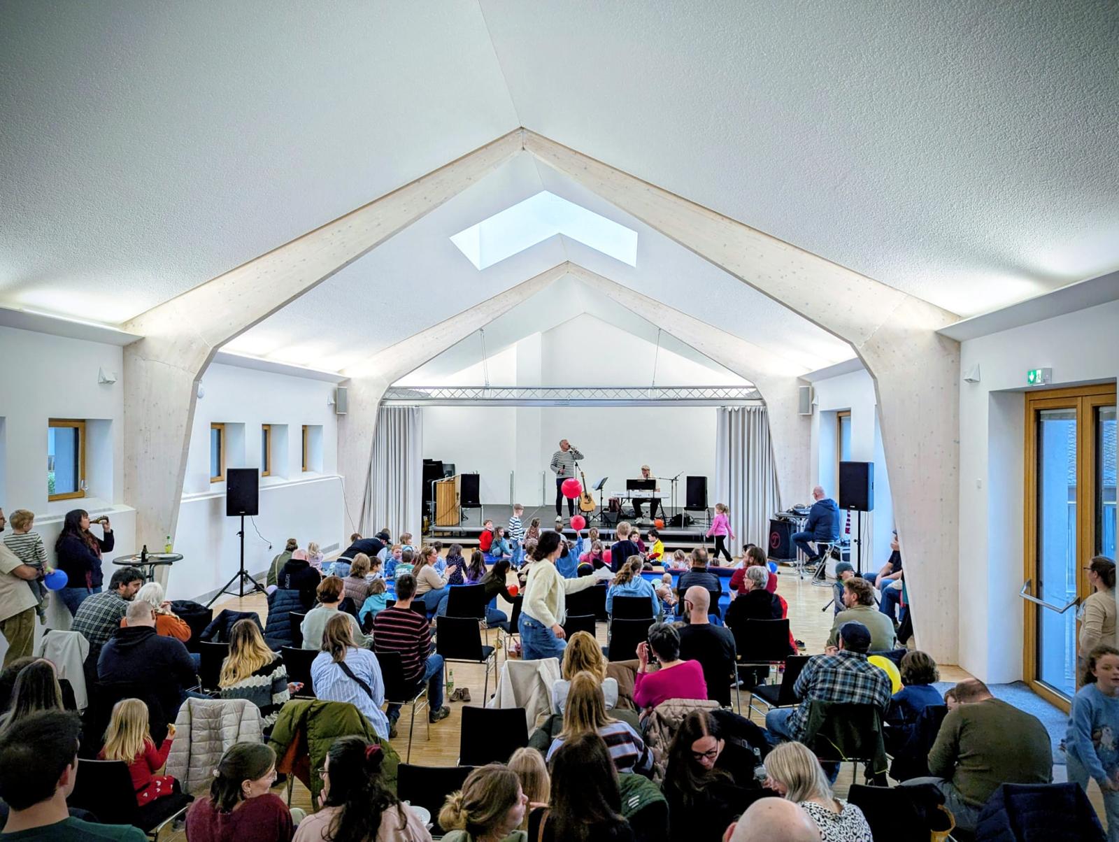 Familien verfolgen das Konzert von Dän im Dorf- und Kulturzentrum Riol
